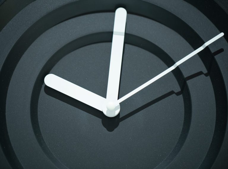 Decorative stylish modern black wall clock. Close up. Decorative stylish modern black wall clock with white hands . Close up. Concept of time.